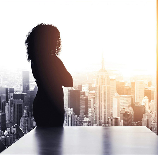 A woman stands in front glass window 
