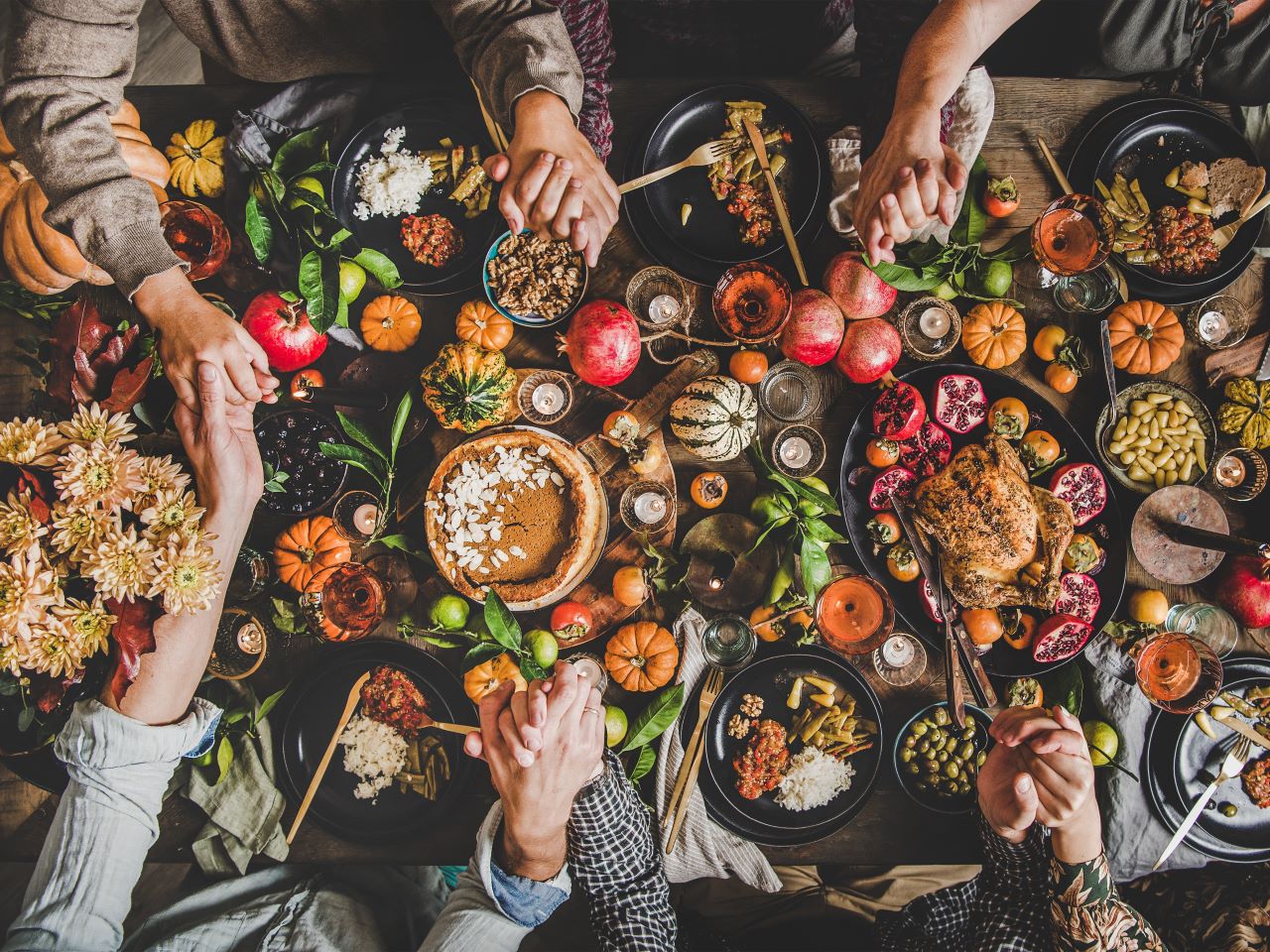 Hands clasped around a table laden with food